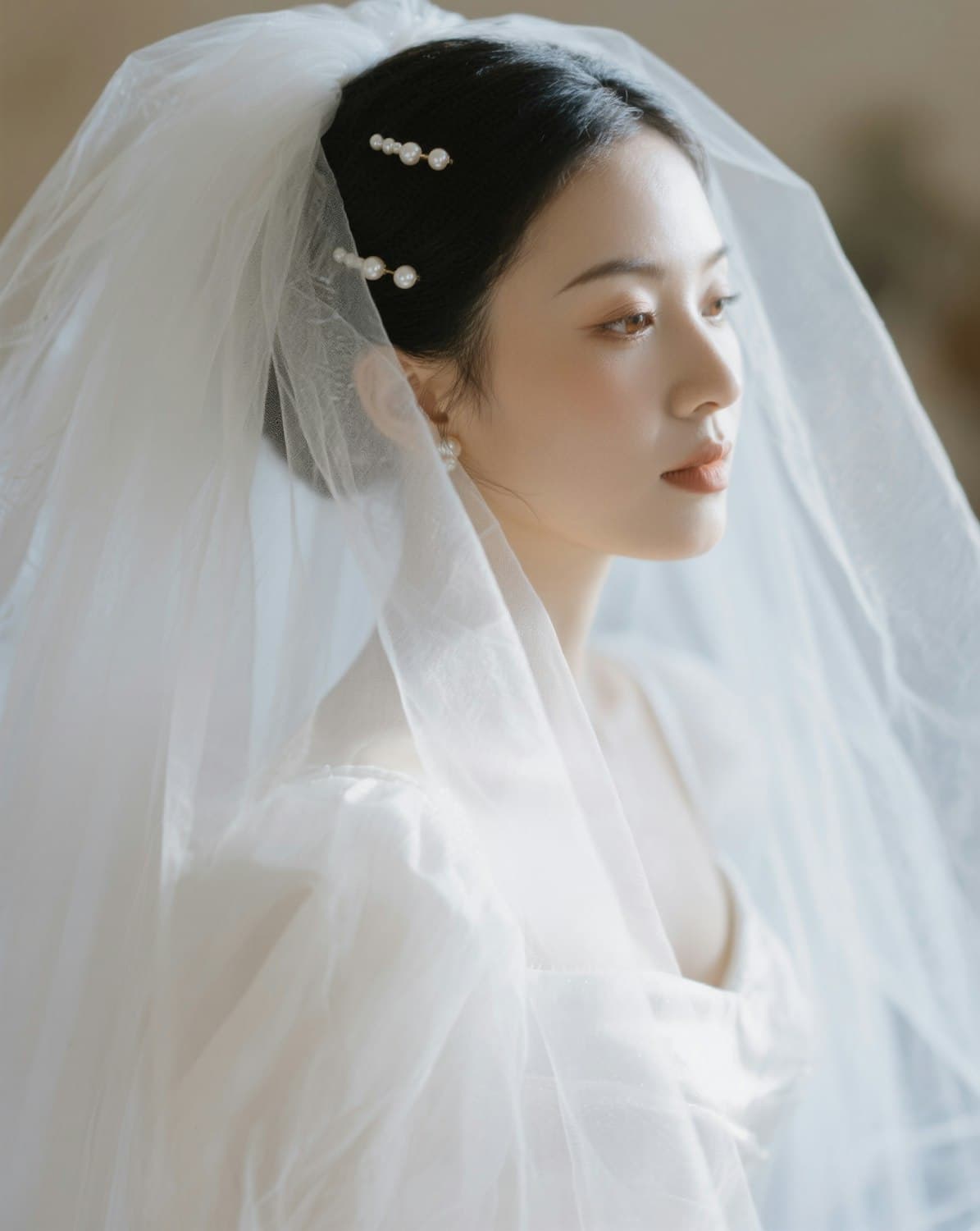 Bride in a white dress and veil with pearl hairpins, photographed in soft daylight